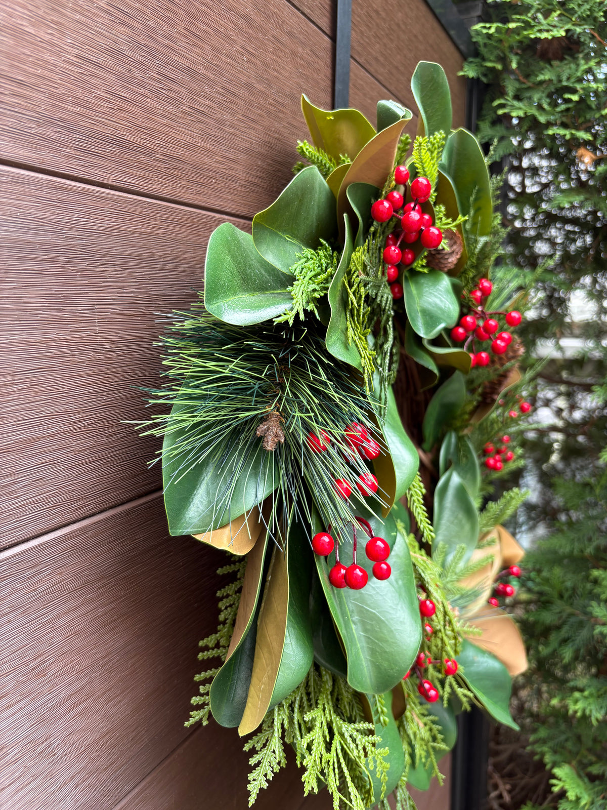Couronne d’hiver en magnolia, cèdre et baies rouges – 23 po