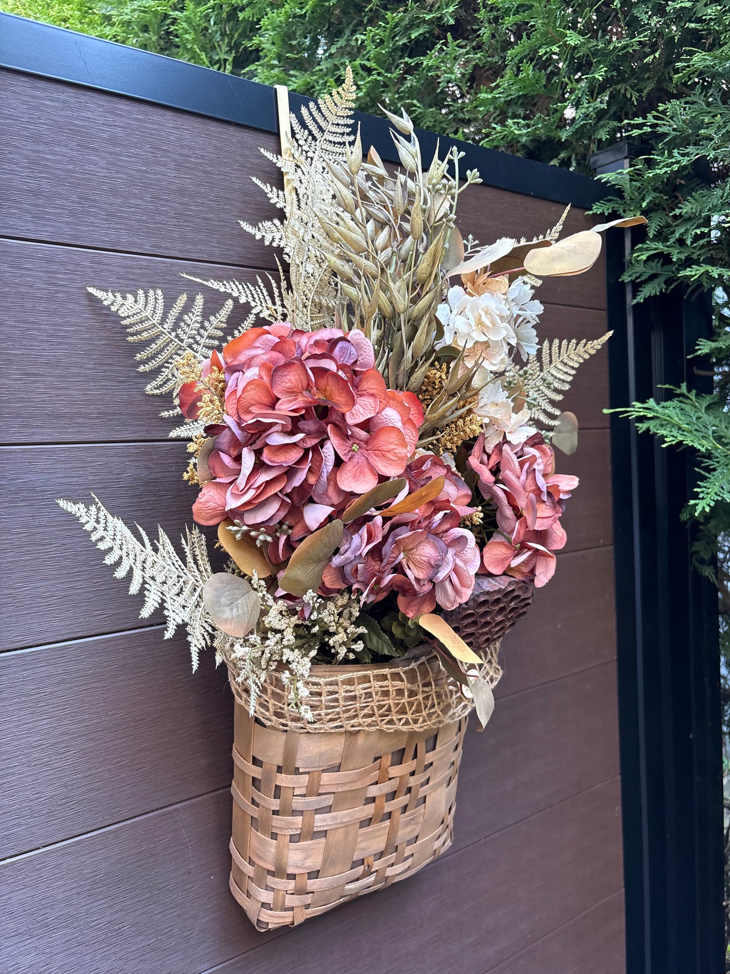 Panier mural d’automne avec hortensias bordeaux vu de côté
