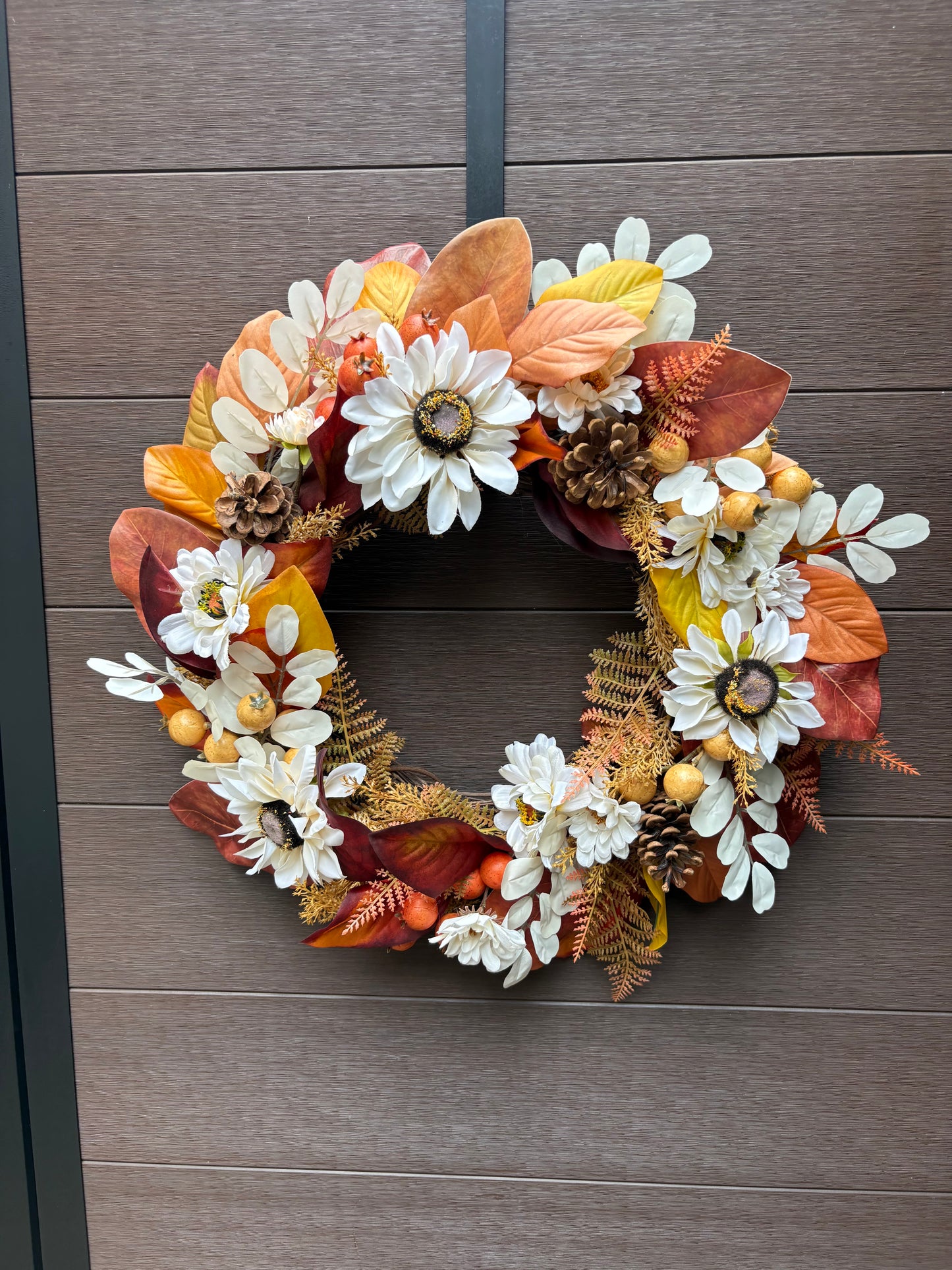Couronne florale d’automne faite à la main sur une porte brune
