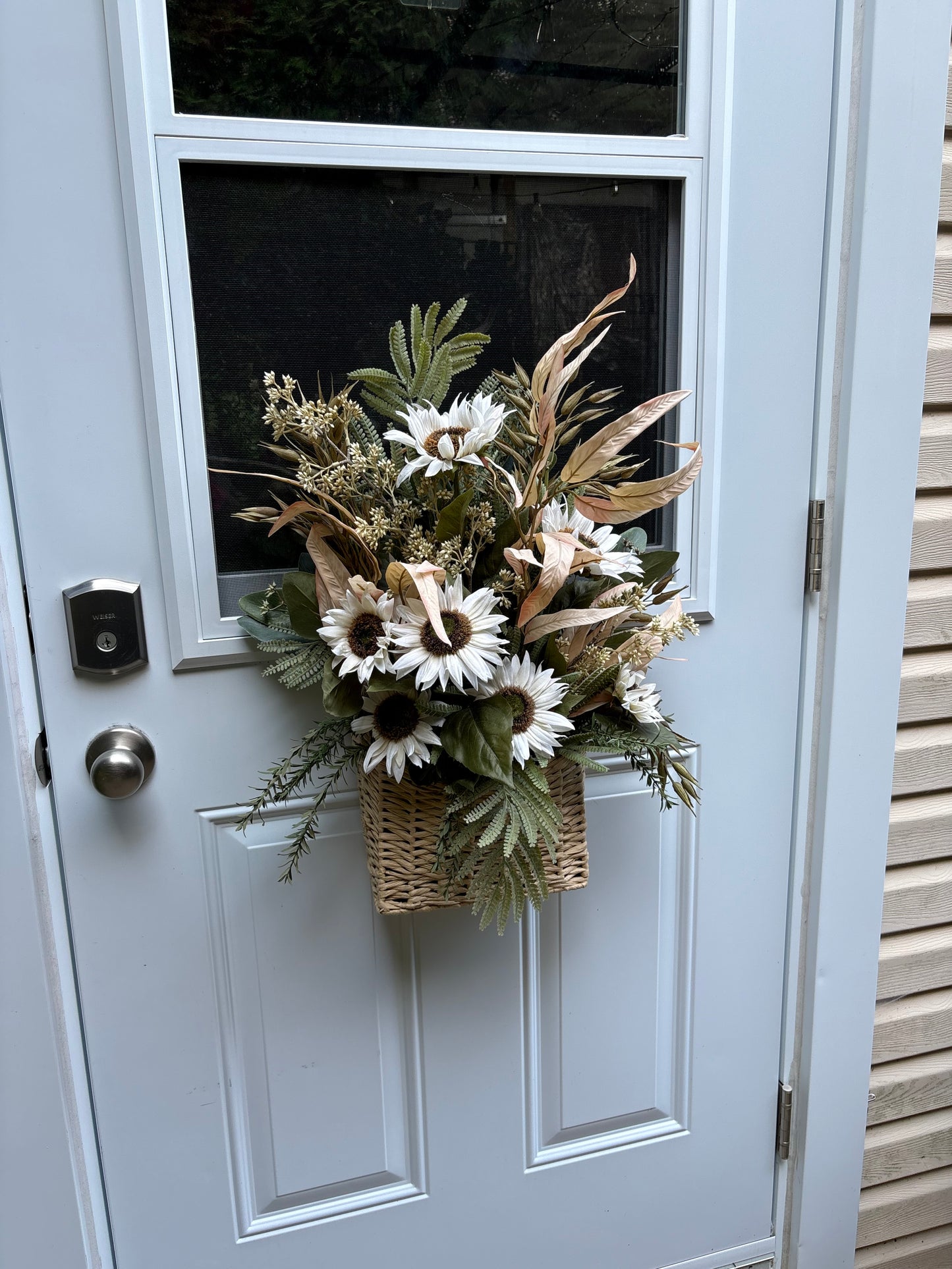 Panier floral d’automne suspendu à une porte d’entrée