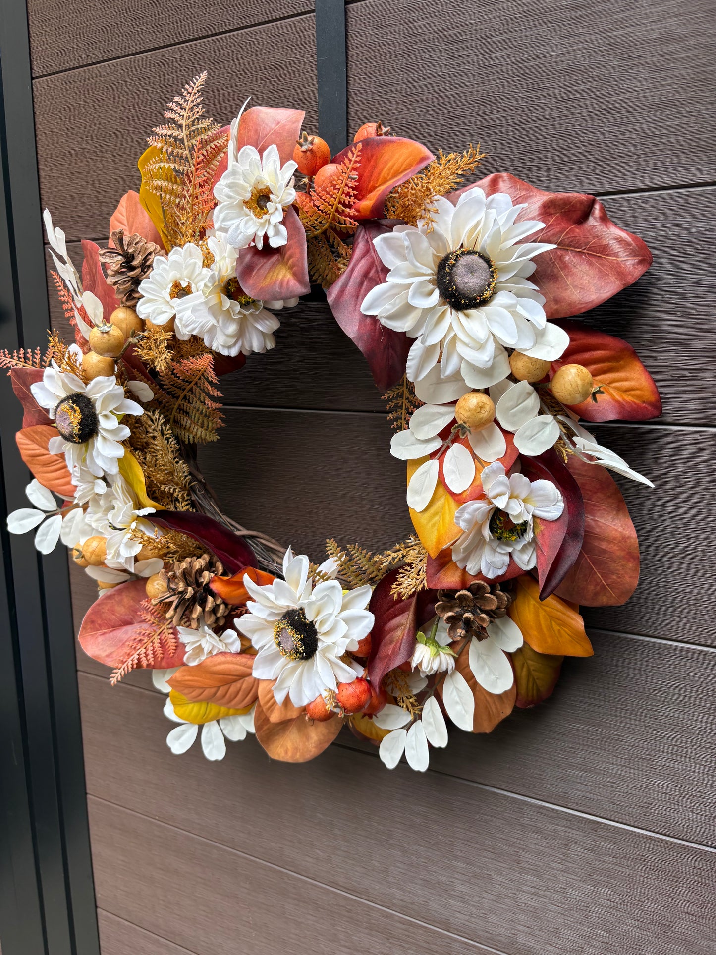 Vue rapprochée de la couronne aux fleurs blanches et feuillages automnaux
