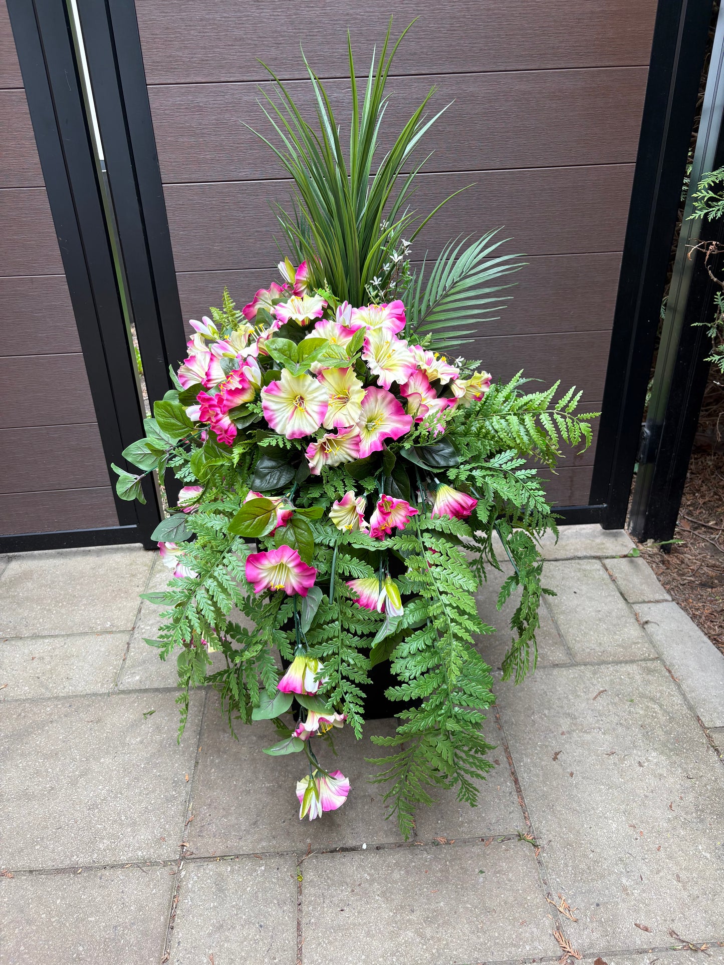 Arrangement floral extérieur UV avec pétunias roses et fougères