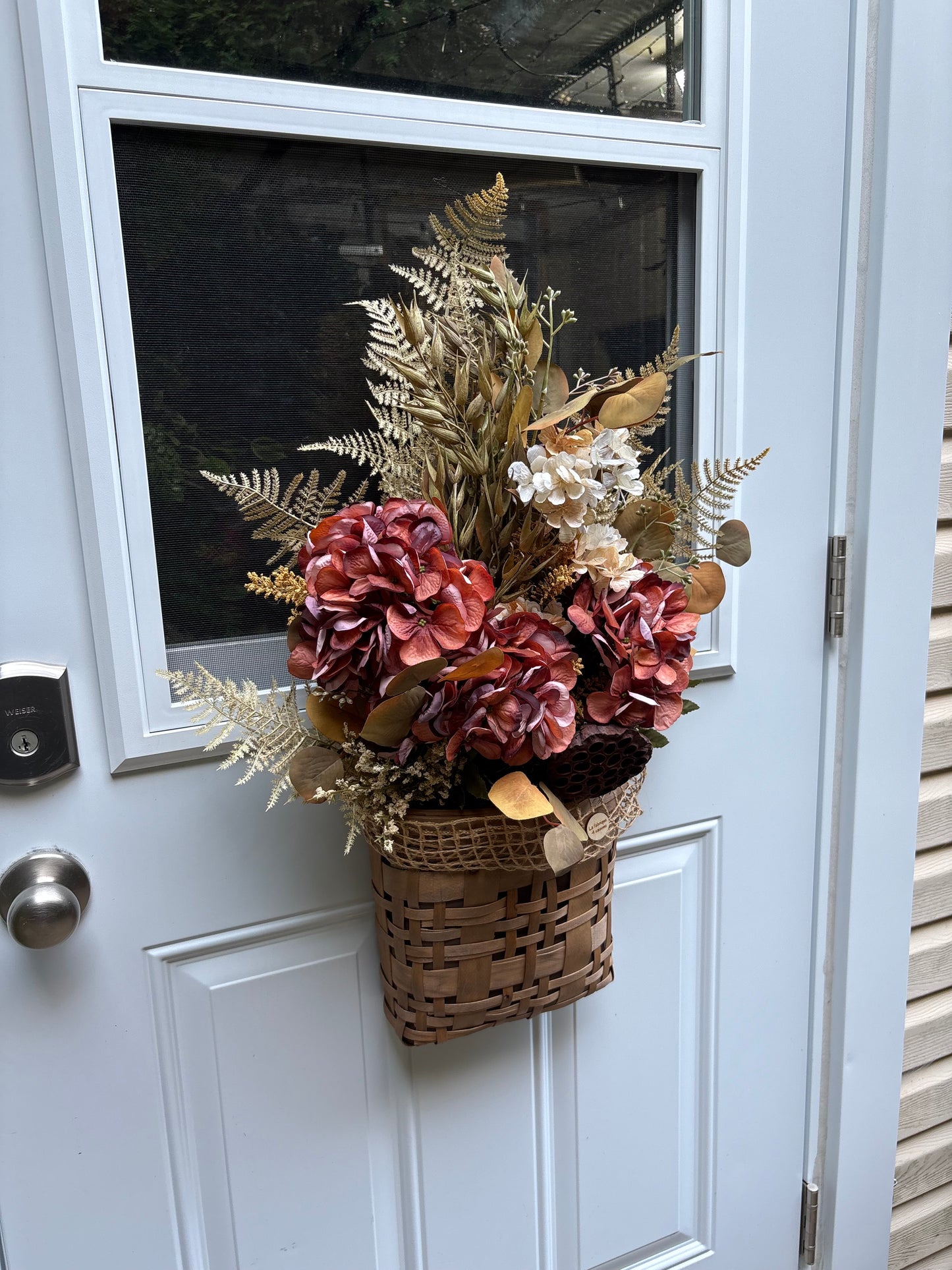 Panier floral d’automne suspendu à une porte d’entrée