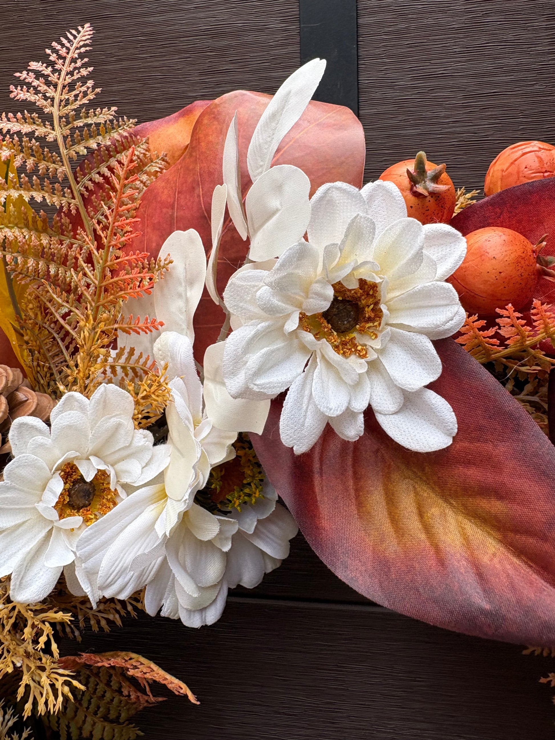 Détail des fleurs blanches et des feuillages cuivrés de la couronne