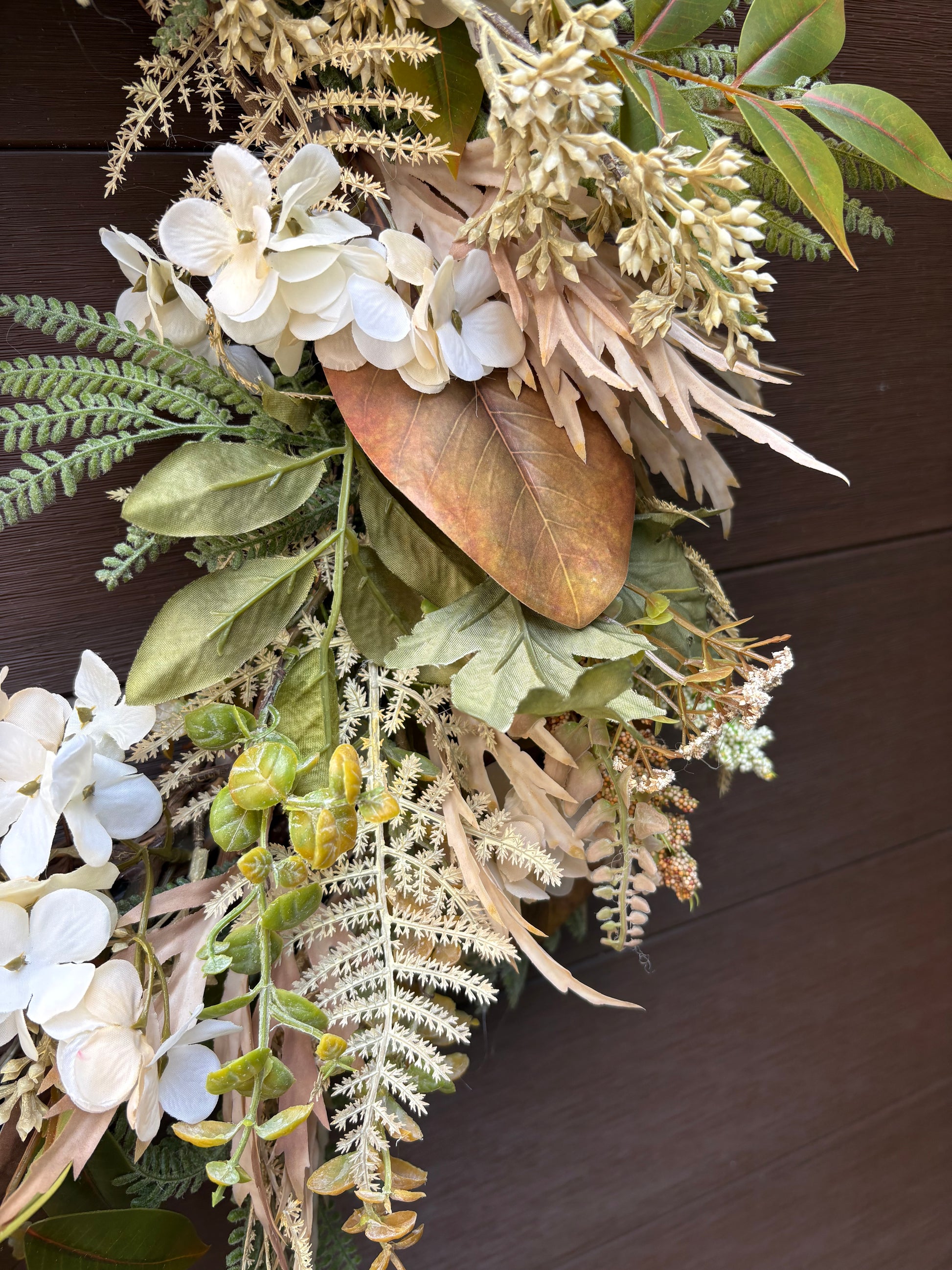 Gros plan sur les fleurs blanches, les fougères et les feuillages bruns