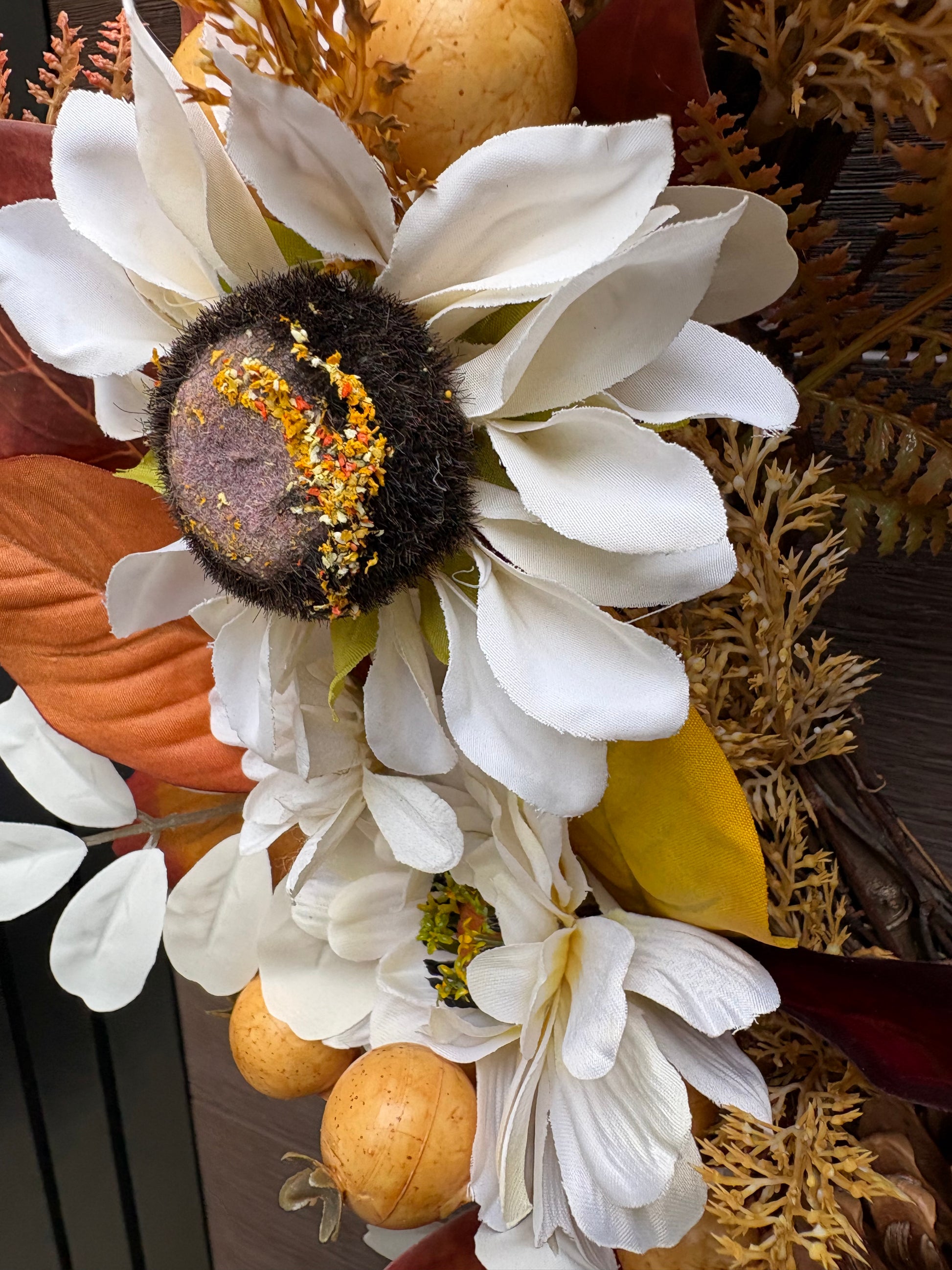 Détail d’une fleur blanche et des petits fruits dorés de la couronne