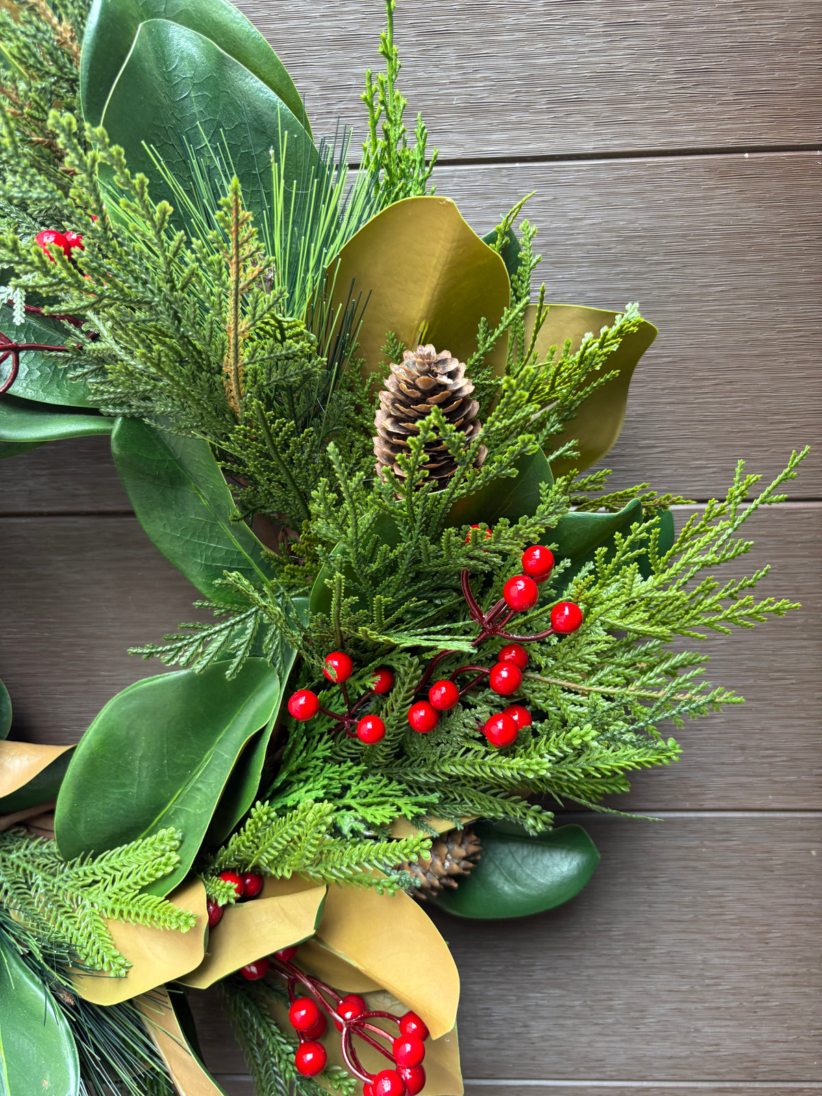 Couronne d’hiver en magnolia, cèdre et baies rouges – 23 po