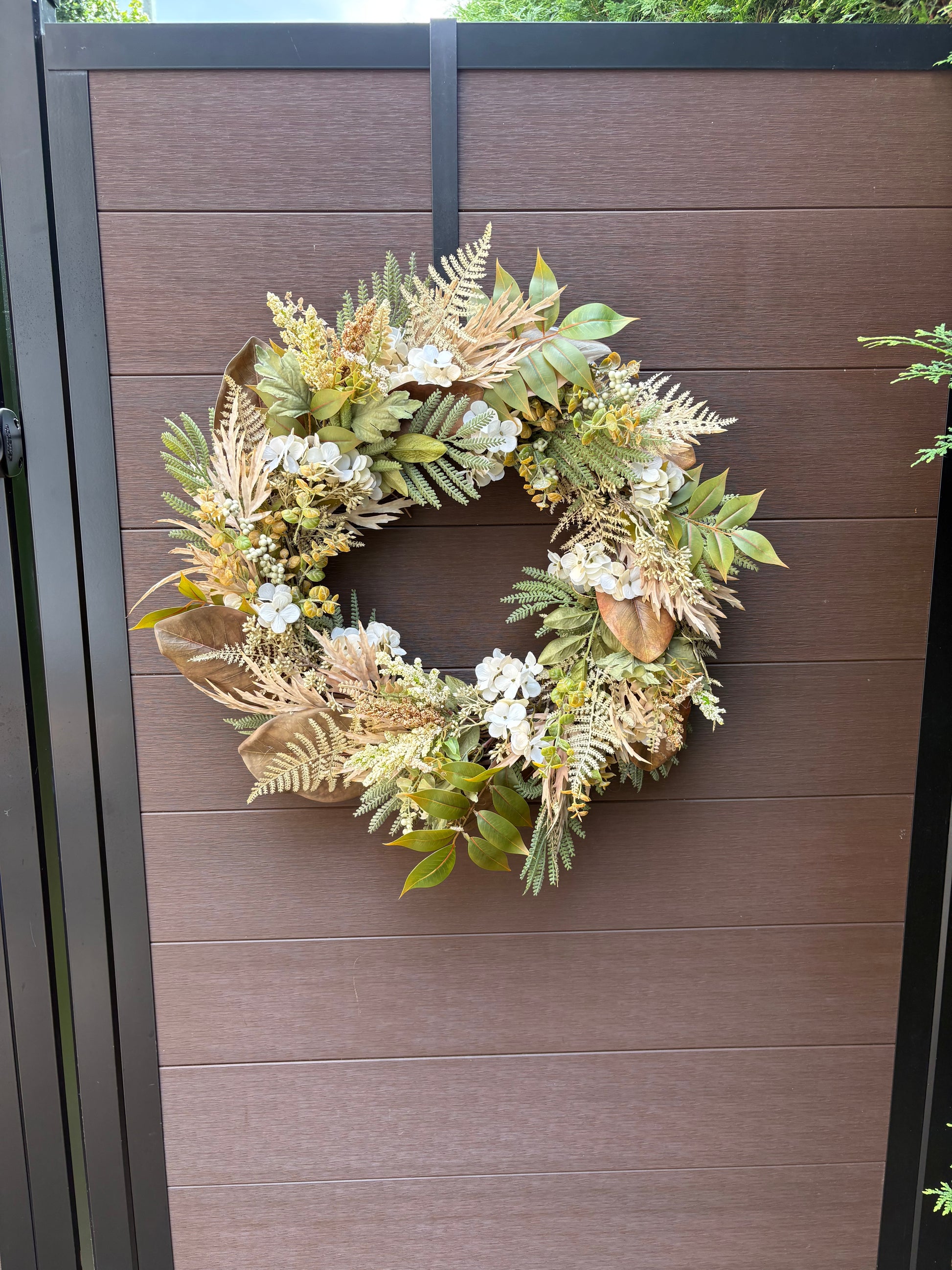 Couronne florale d’automne faite à la main sur une porte brune
