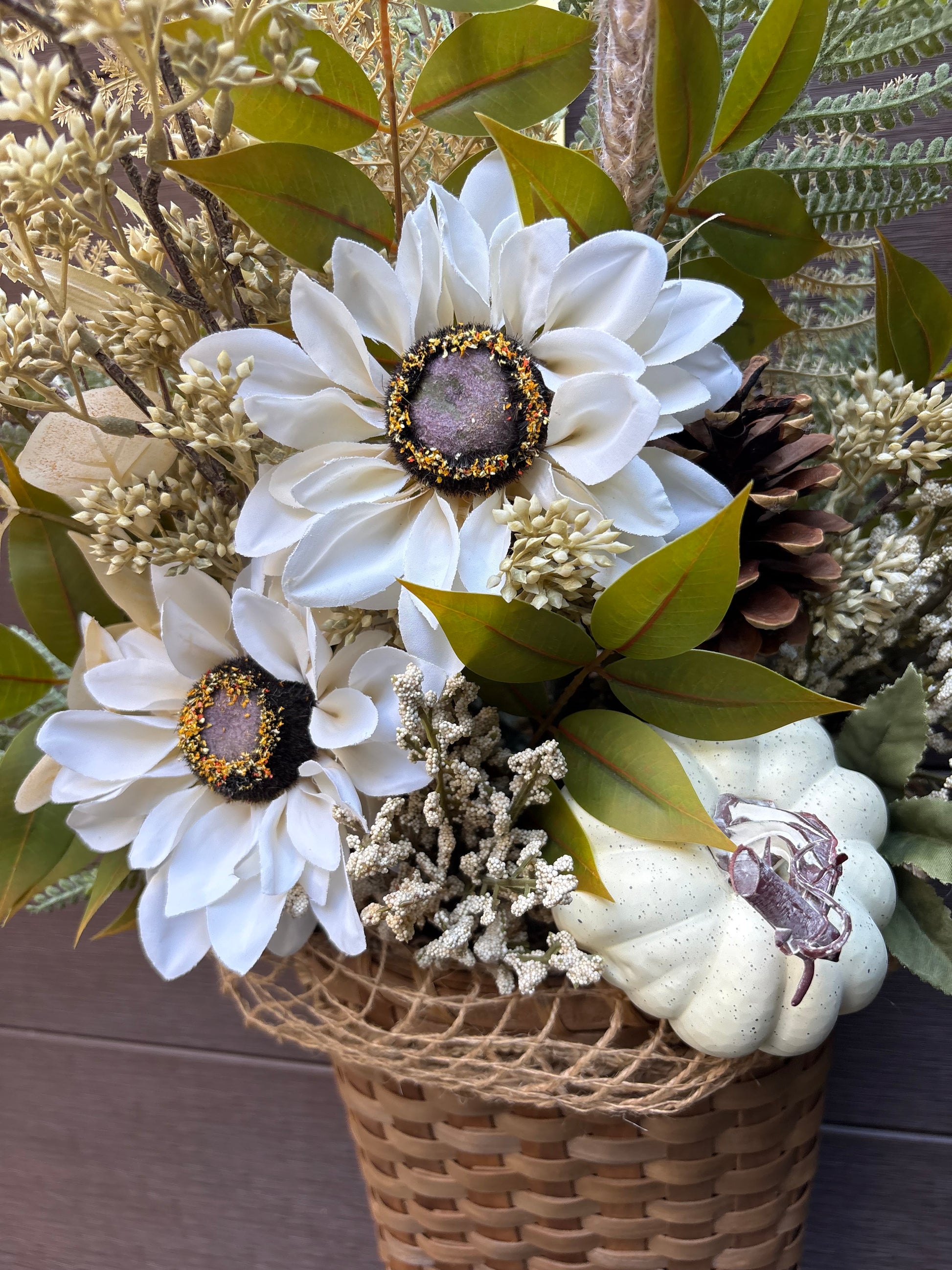 Détail de la citrouille crème et des fleurs artificielles du panier