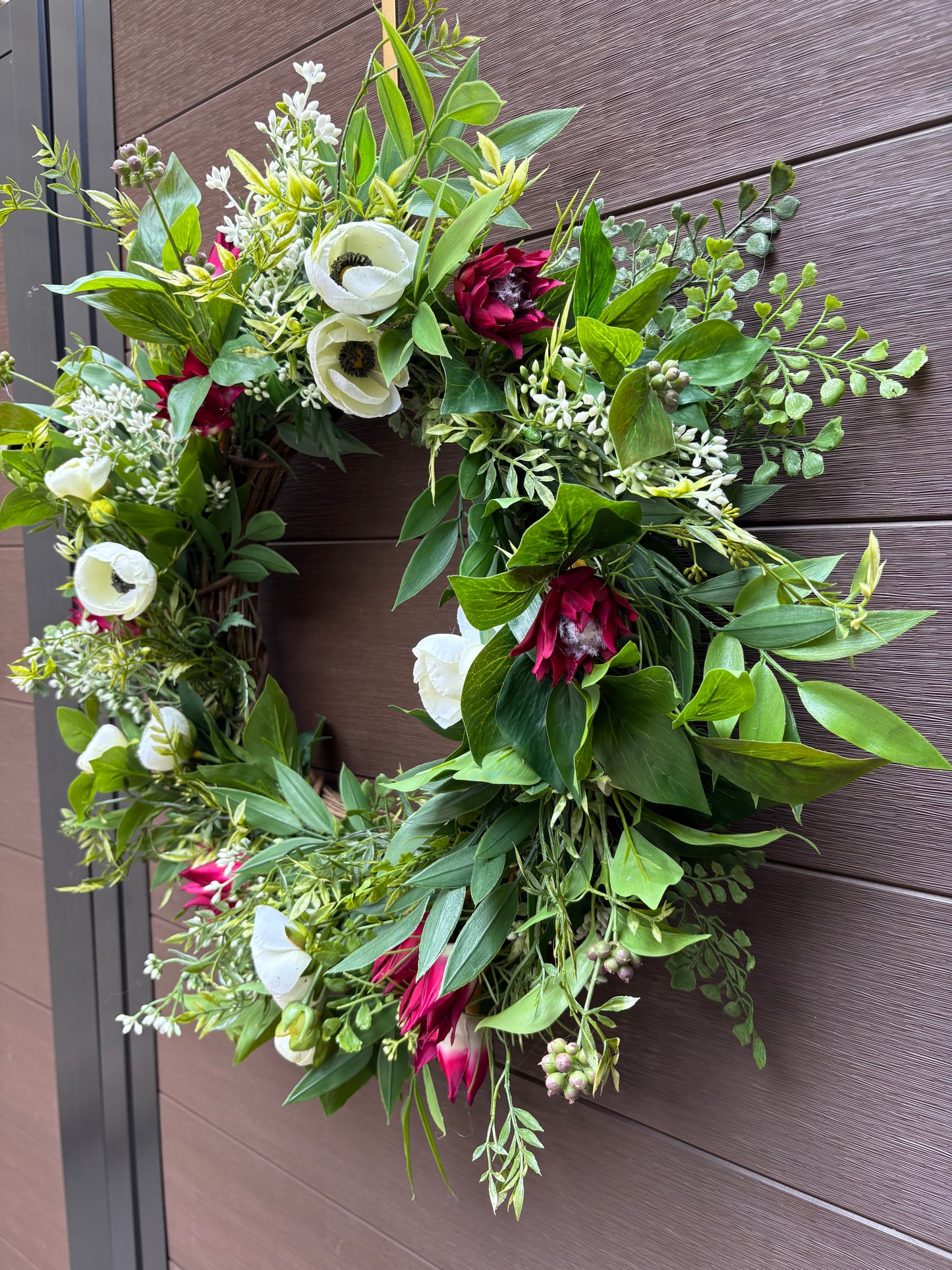 Couronne florale ruscus, fougère, ranunculus et protea sauvage
