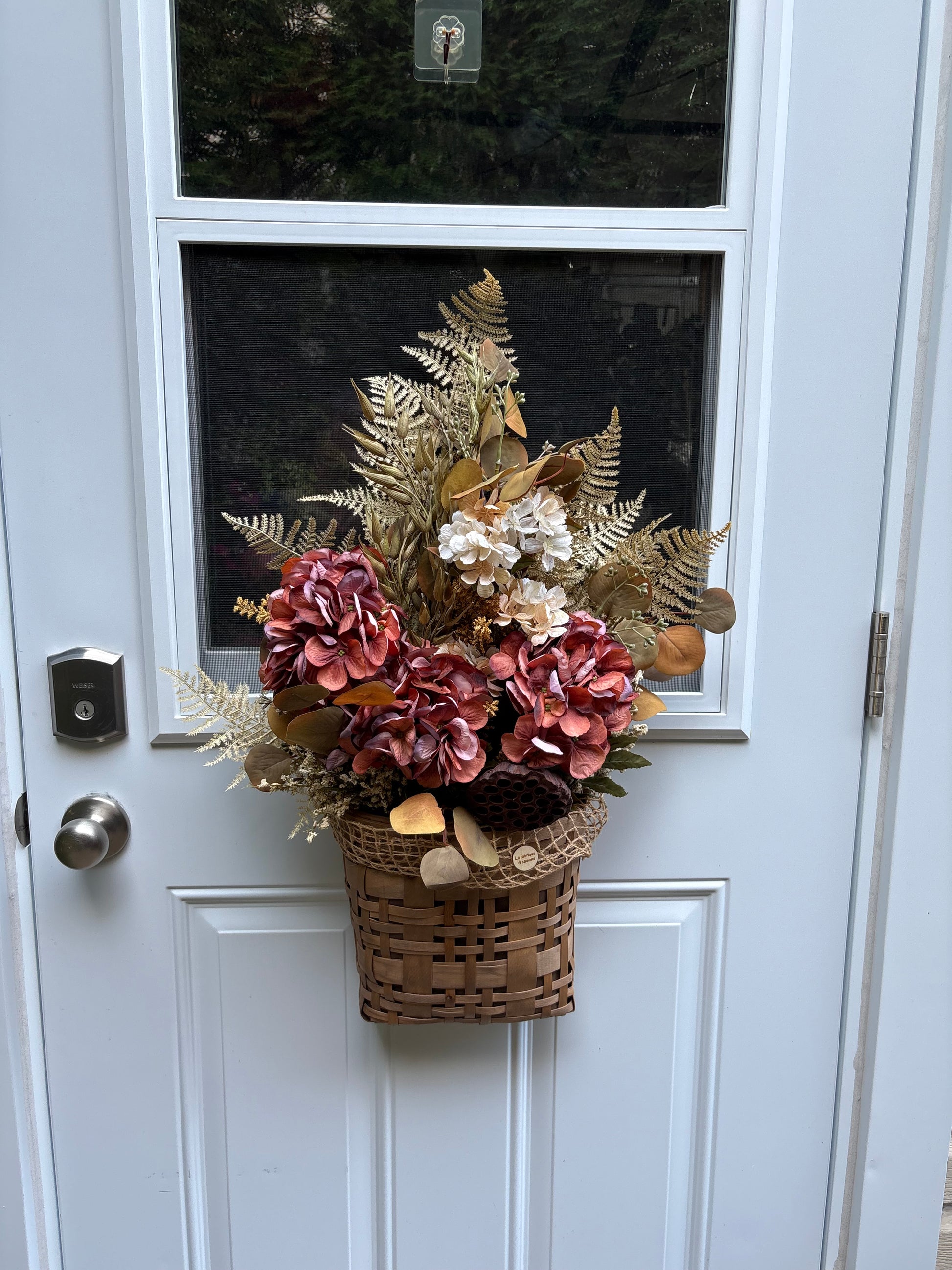 Panier floral d’automne suspendu à une porte d’entrée