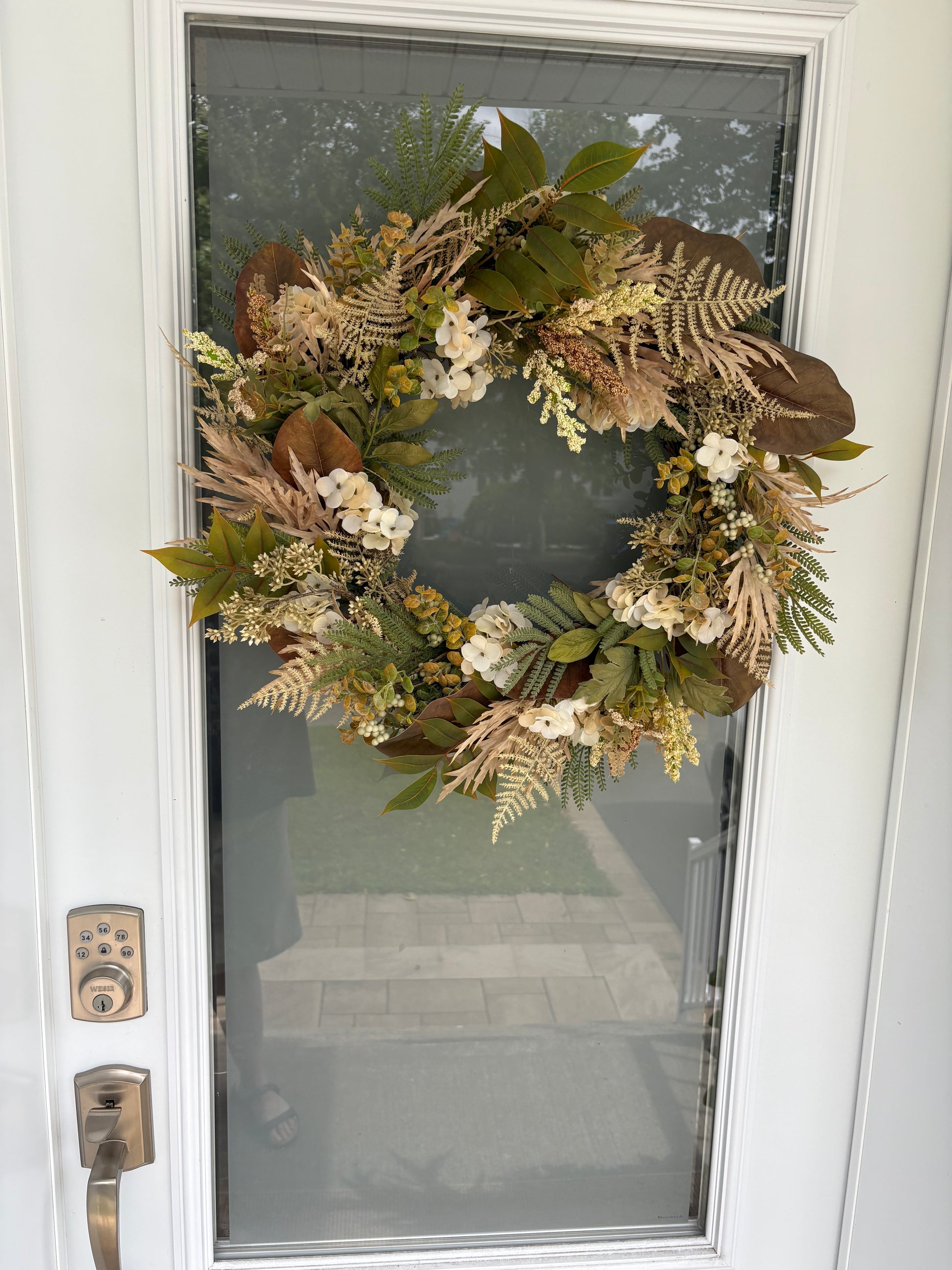 Couronne d’automne naturelle présentée sur une porte d’entrée grise