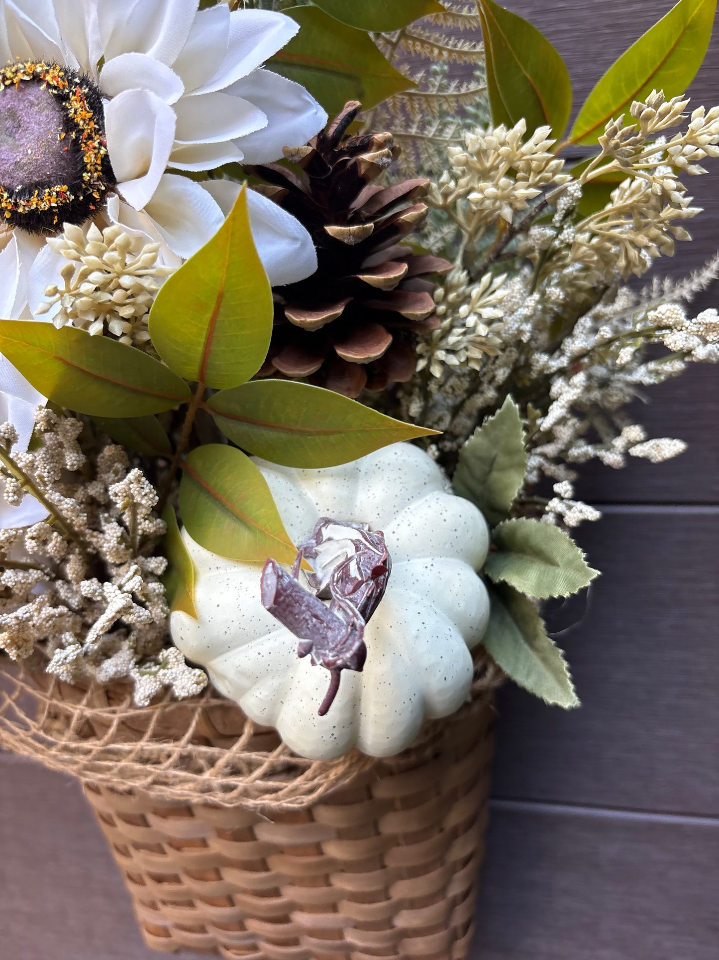 Détail de la citrouille crème et des fleurs artificielles du panier