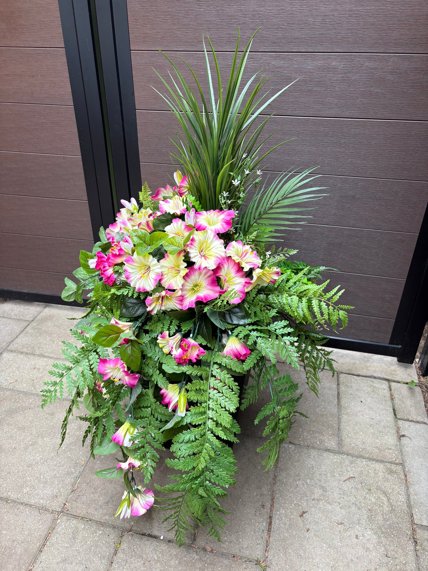 Arrangement floral extérieur UV avec pétunias roses et fougères