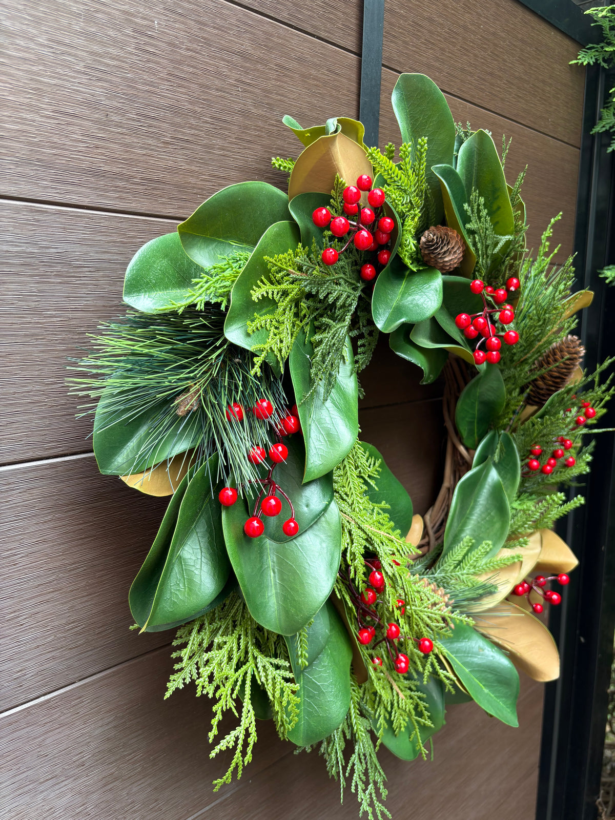 Couronne d’hiver en magnolia, cèdre et baies rouges – 23 po