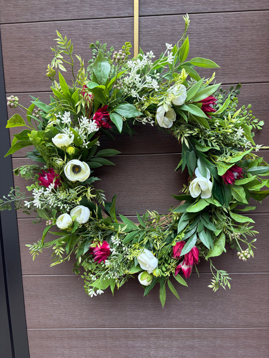 Ruscus, fern, ranunculus, and wild protea floral wreath