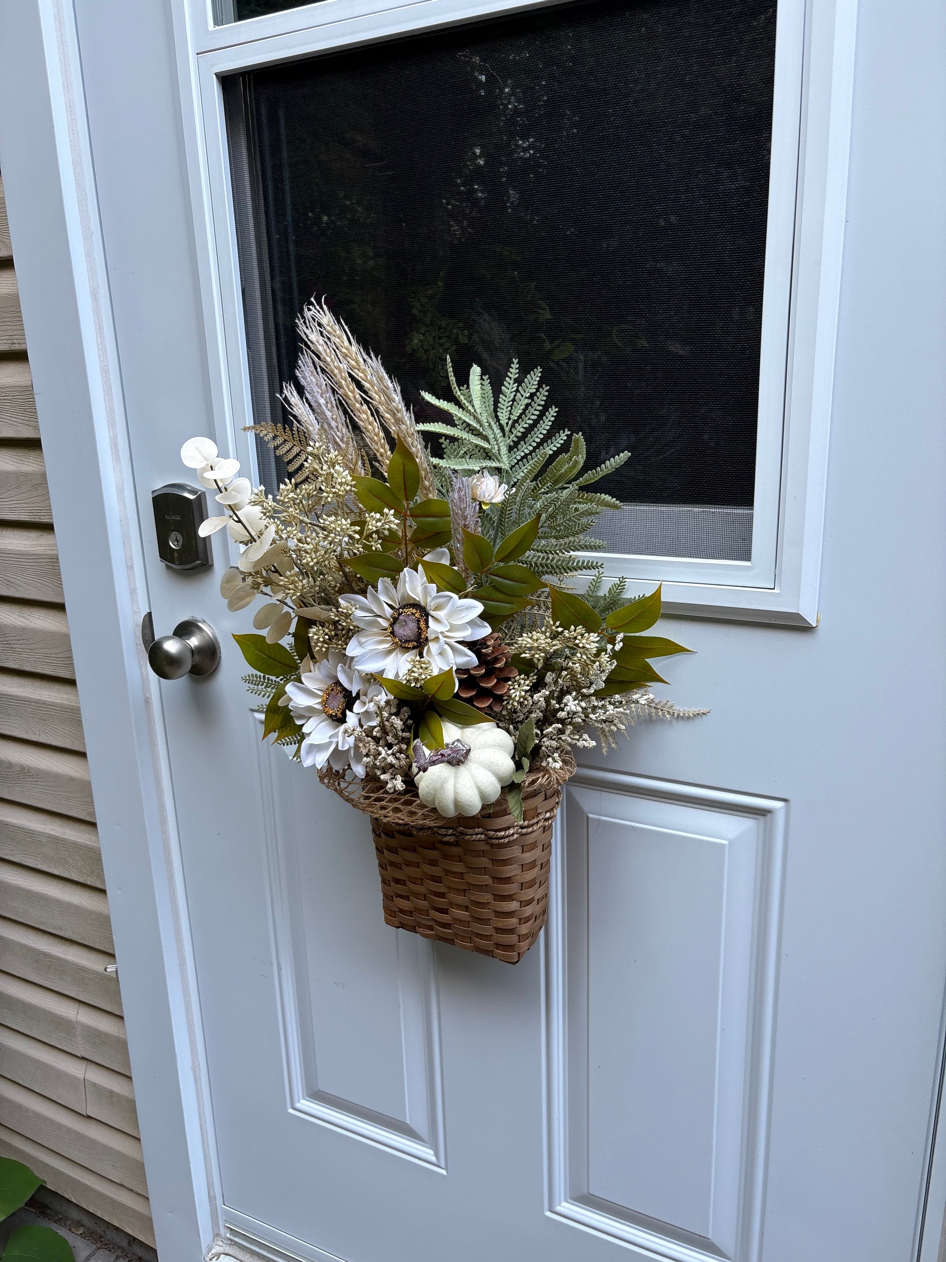 Arrangement floral d’automne suspendu sur une porte d’entrée