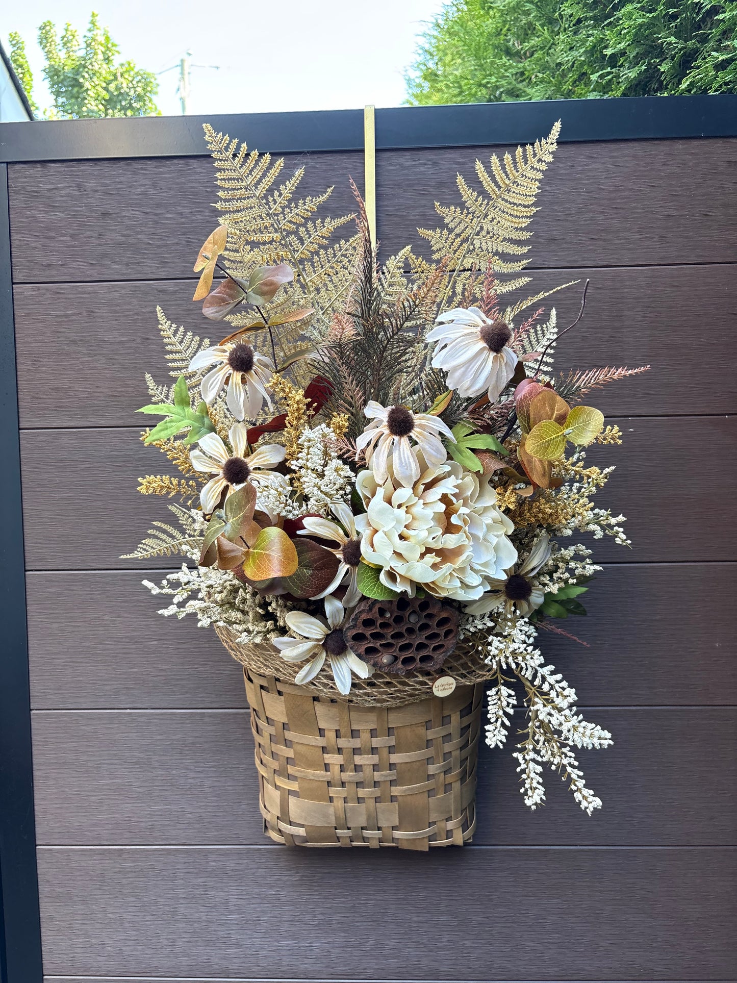 Panier mural d’automne en osier avec fleurs crème, feuillages naturels et fougères artificielles
