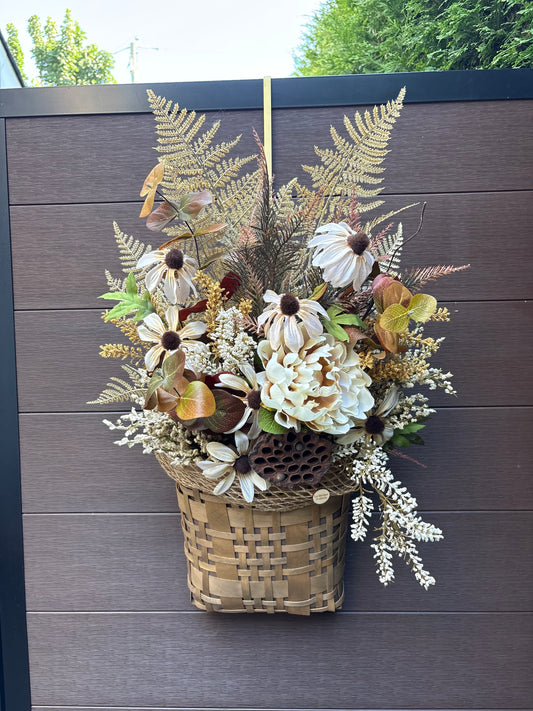 Panier mural d’automne en osier avec fleurs crème, feuillages naturels et fougères artificielles