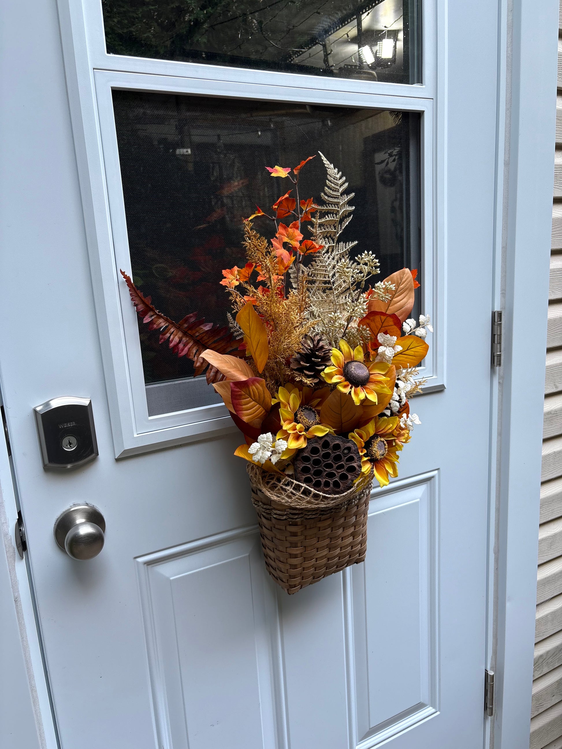 Arrangement d’automne artificiel suspendu à une porte d’entrée