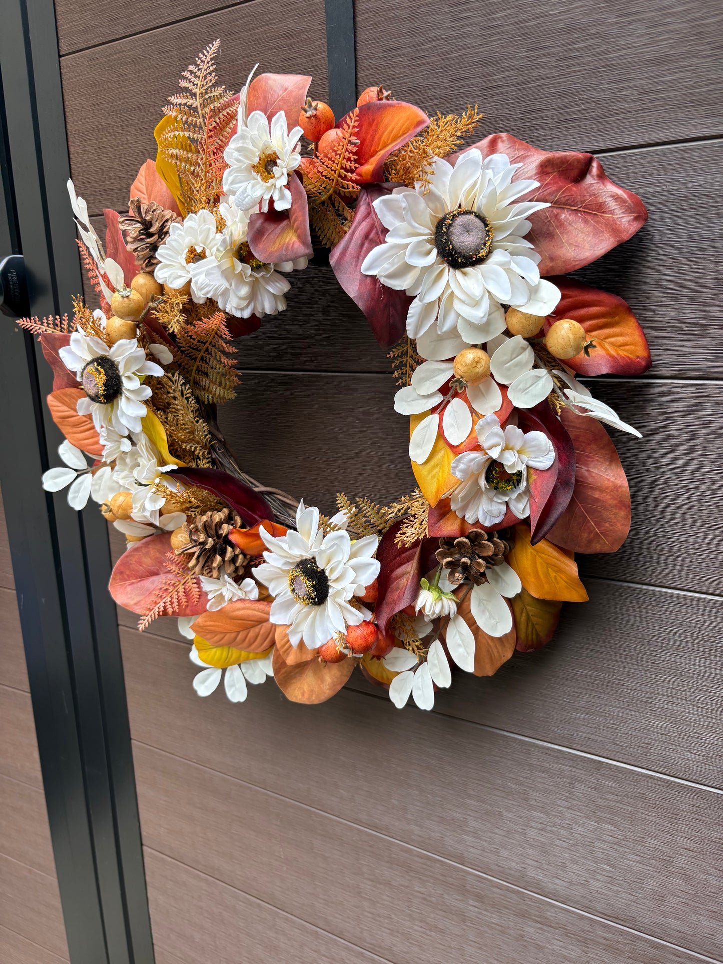 Couronne artisanale aux fleurs blanches et aux feuilles orangées