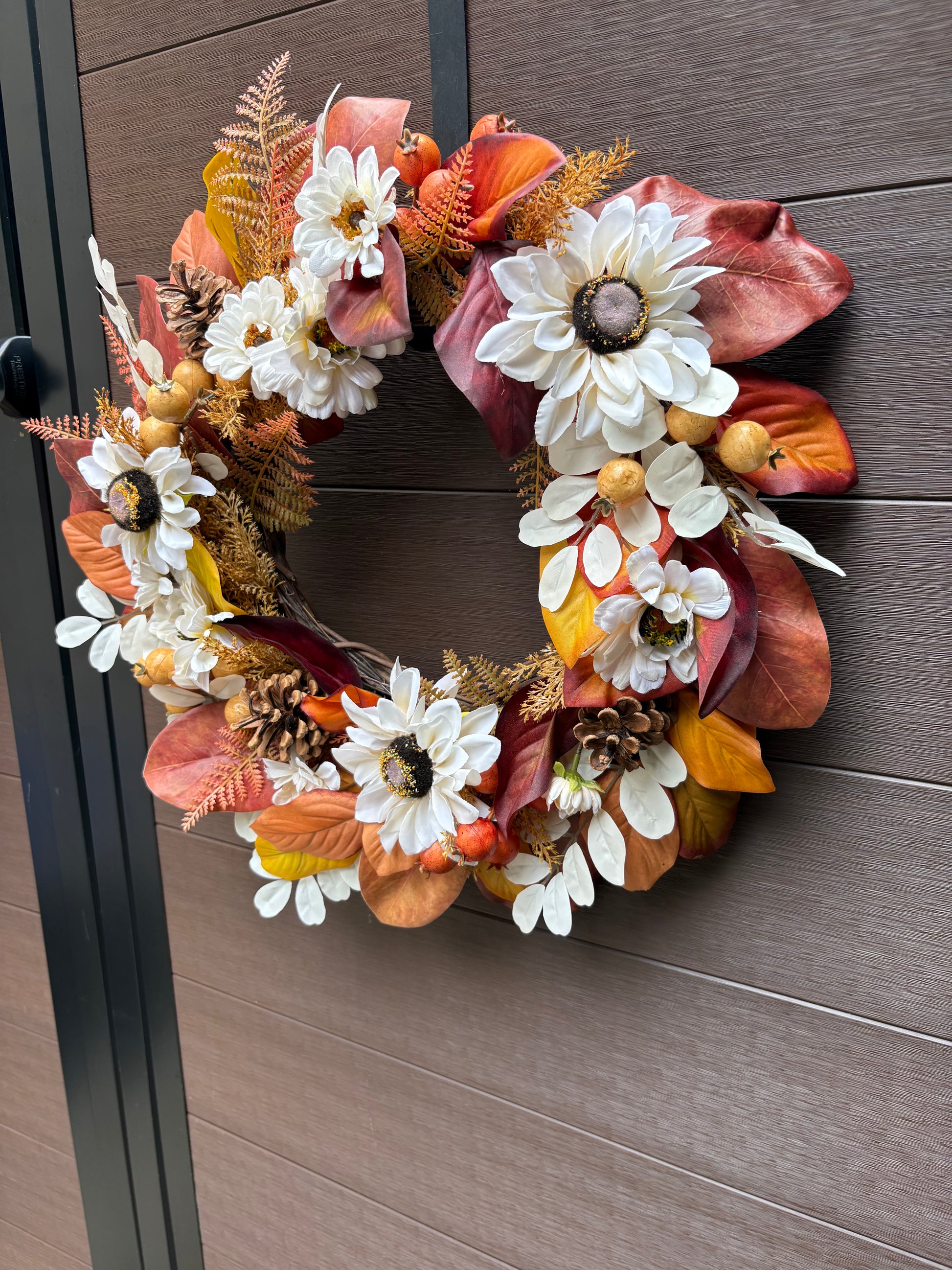 Couronne artisanale aux fleurs blanches et aux feuilles orangées