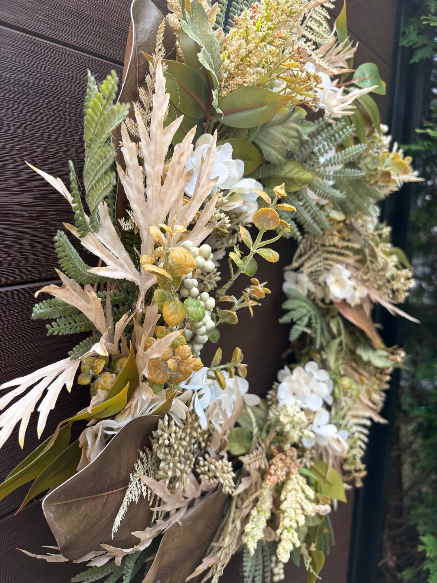 Détail latéral des fleurs et feuillages artificiels de la couronne