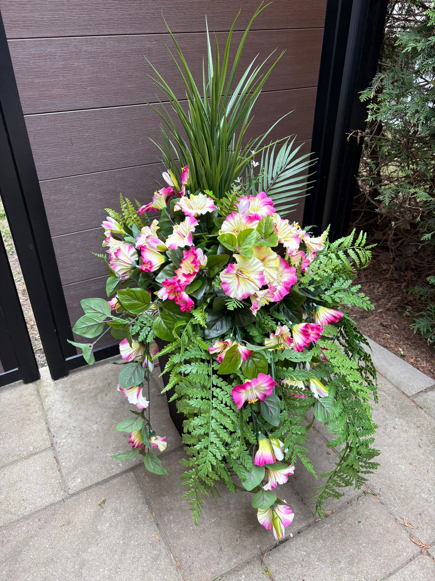 Arrangement floral extérieur UV avec pétunias roses et fougères