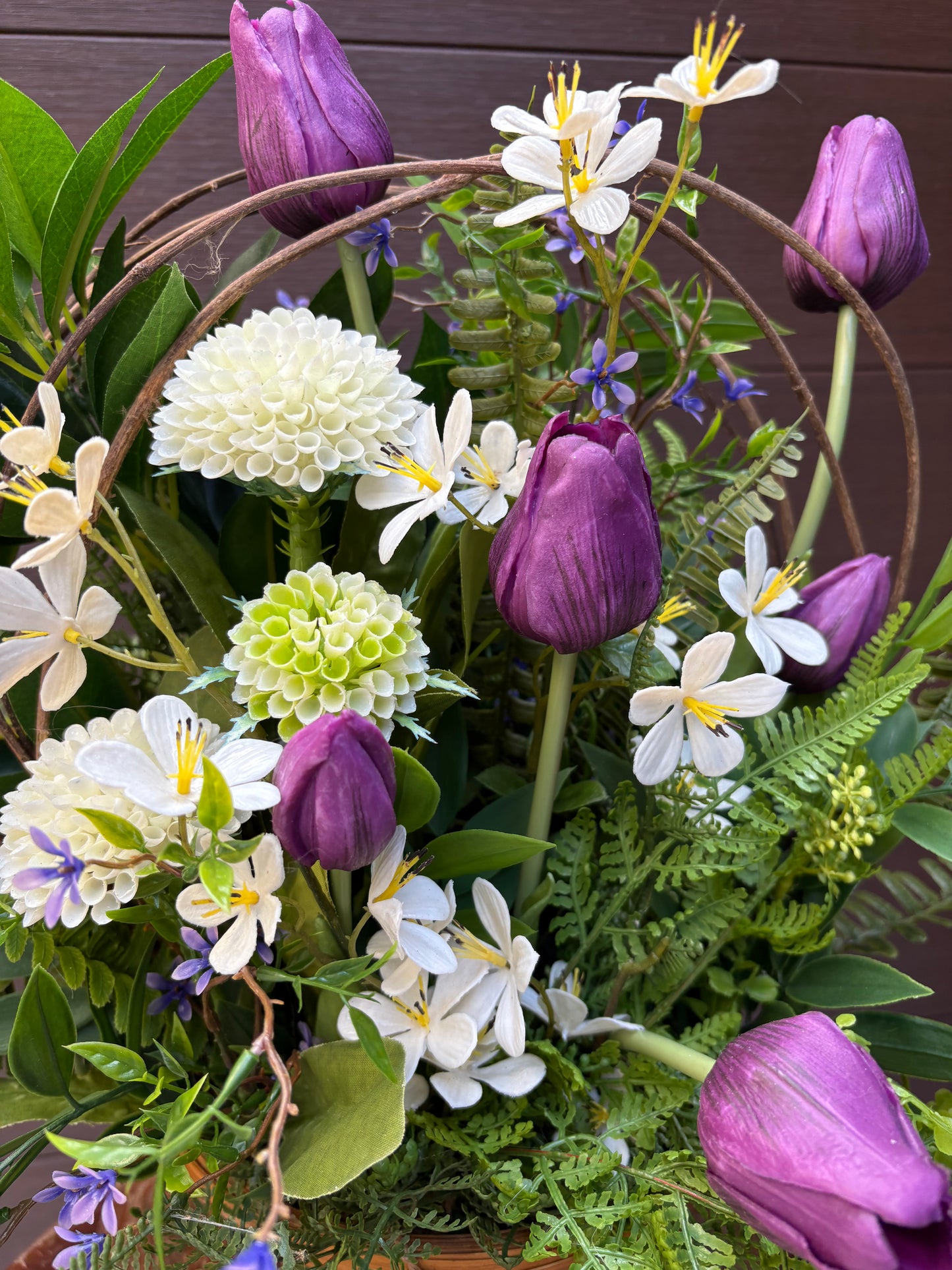 Arrangement floral en pot effet bois avec tulipes mauves et verdure champêtre