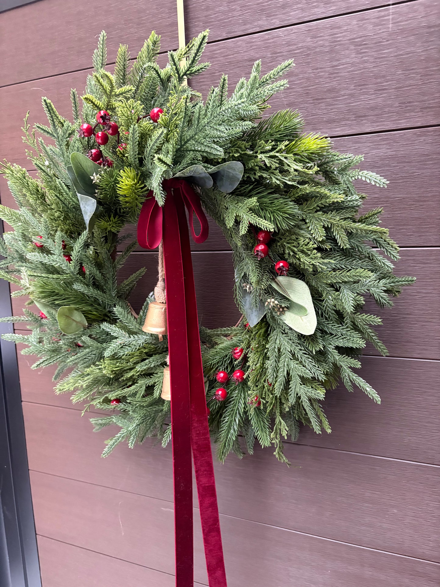 Grande couronne de Noël pour porte d’entrée – Pin, eucalyptus et baies rouges avec ruban bourgogne et cloches – 26 pouces