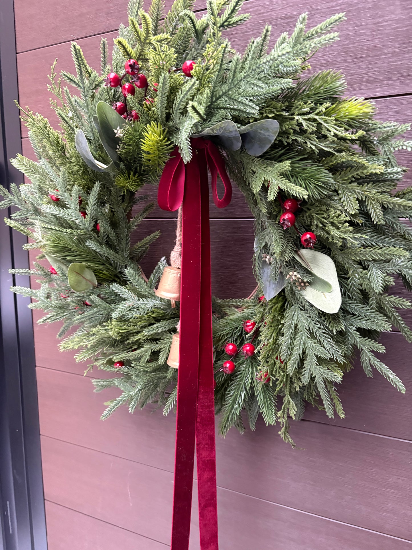 Grande couronne de Noël pour porte d’entrée – Pin, eucalyptus et baies rouges avec ruban bourgogne et cloches – 26 pouces