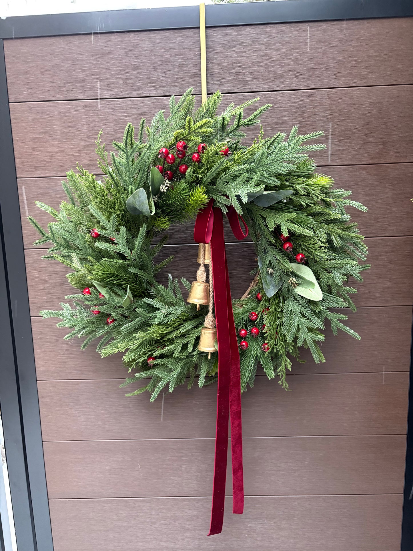 Grande couronne de Noël pour porte d’entrée – Pin, eucalyptus et baies rouges avec ruban bourgogne et cloches – 26 pouces