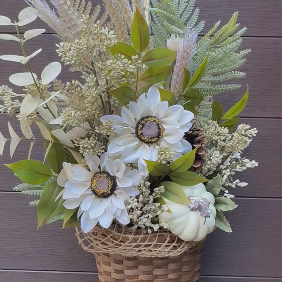 anier en osier garni de fleurs blanches et feuillages automnaux